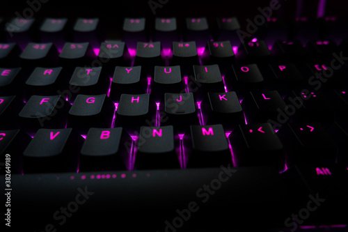Close-up of pink backlit keyboard. Gaming keyboard.
