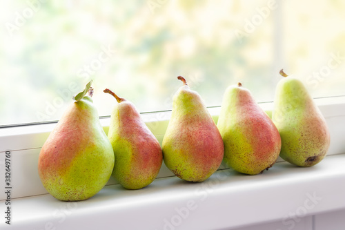 Pears on the windowsill. Juicy pears are stacked in a row. Fruit harvest. Selective soft focus. Healthy organic food.