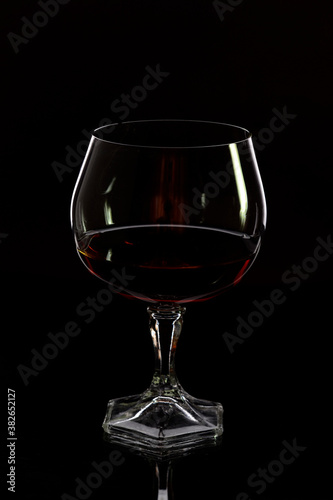 Glass with cognac on a black background