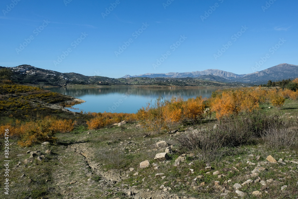Blue lake landscape near malaga in spain with a lof of rocks and plants
