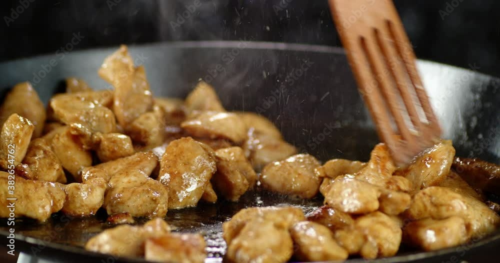 Pieces of chicken fillet with spices stirred in a pan. Pieces of chicken fillet with spices stirred in a pan.