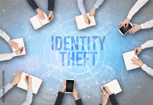 Group of people in front of a laptop with IDENTITY THEFT insciption, web security concept