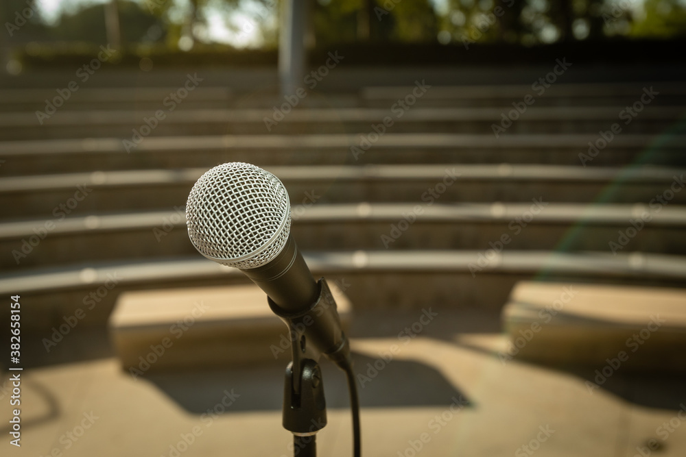 Microphone Stand in Empty Amphitheater with No People Outside at Sunset for Comedy Show or Live Entertainment Microphone Stand in Empty Amphitheater with No People Outside at Sunset for Comedy Show or Live Entertainment
