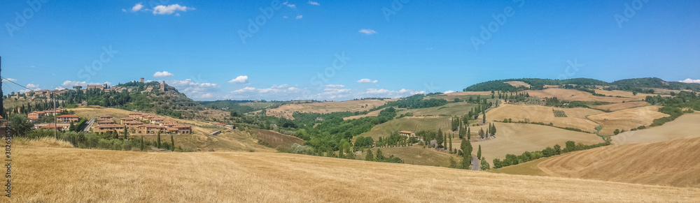 Ultra wide view of Tuscan hills with many cypresses