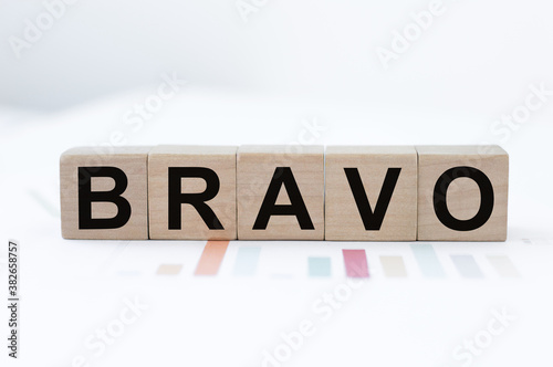BRAVO text on wood cubes on a table with paper charts