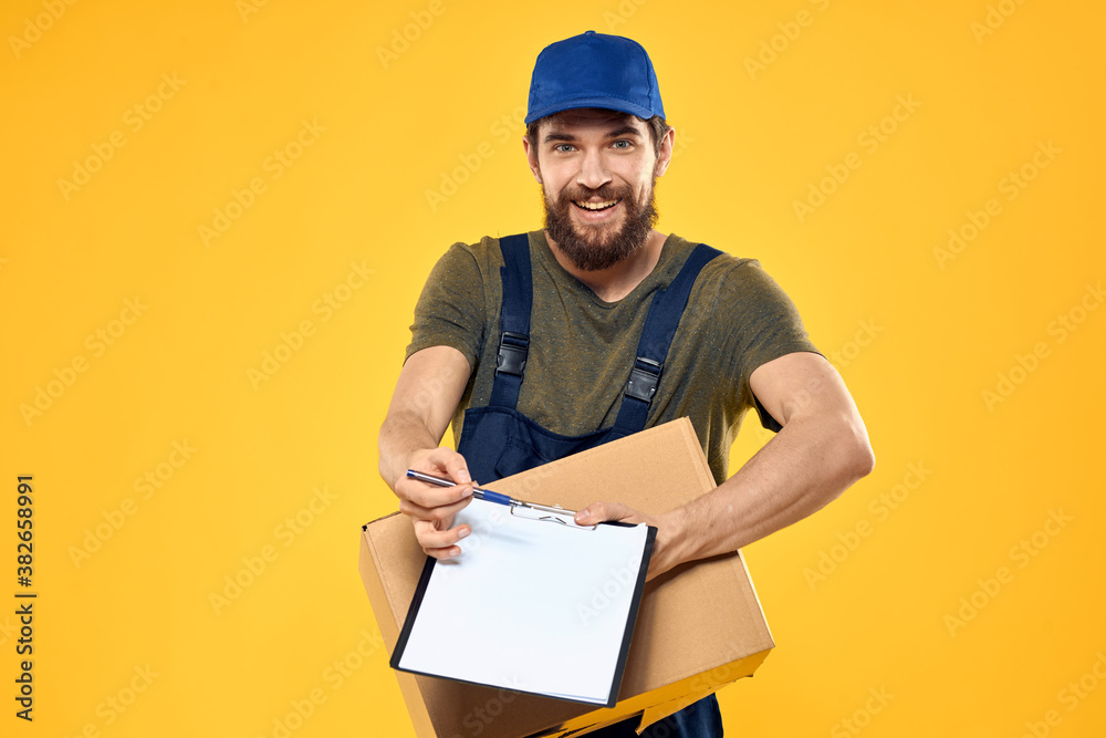 Worker male courier delivering boxes packaging documents yellow background Worker male courier delivering boxes packaging documents yellow background