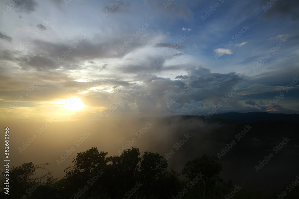Destination twilight and paradise of golden sunrise and sunset shining to the mist and fog in the jungle on the valley mountain. Aerial view of Rainy season in the tropical rainforest in Thailand.