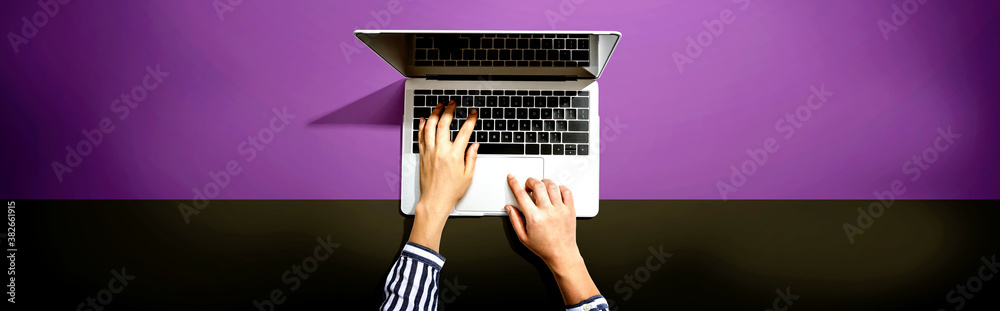 Person using a laptop computer from above Person using a laptop computer from above