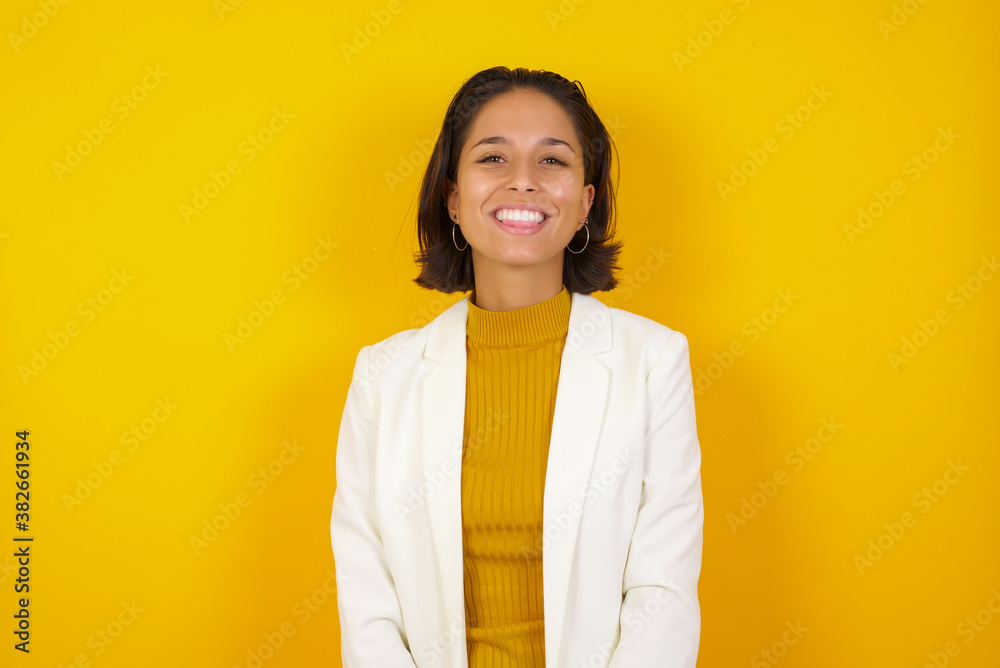 Beautiful Young caucasian woman with happy and funny face smiling and showing tongue. Wearing casual clothes and standing against gray studio background. Beautiful Young caucasian woman with happy and funny face smiling and showing tongue. Wearing casual clothes and standing against gray studio background.