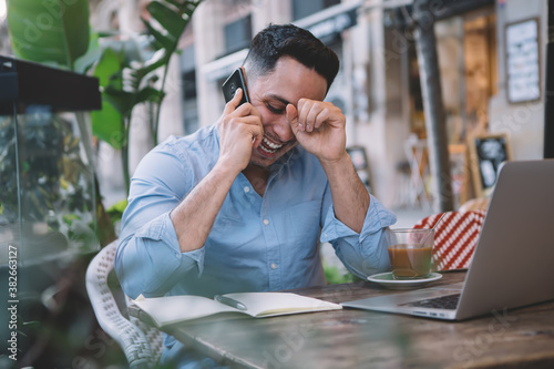 Foto Happy man hearing good news while talking on phone