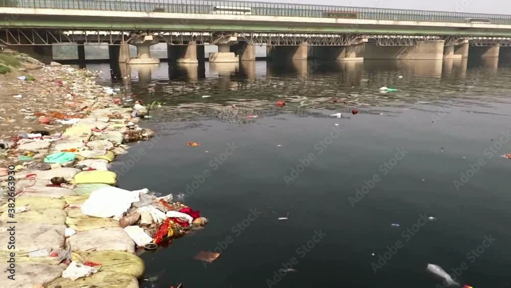 Medium, trash floating in the polluted waters of Yamuna River, New Delhi, India