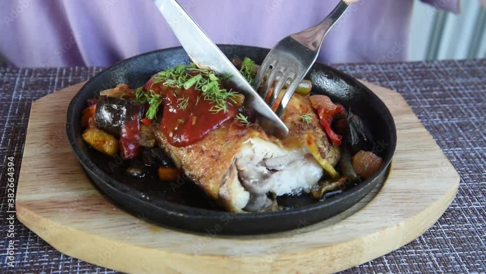 Fried chicken with vegetables. The lunch process. The knife cuts the dish. Fried chicken with vegetables. The lunch process. The knife cuts the dish.