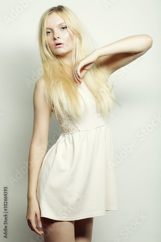 fashion blond woman in white dress posing in studio