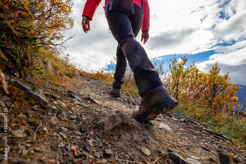 View of Woman Hiking Rocky Trail from Below during Fall in Canadian Nature. Taken in Tombstone Territorial Park, Yukon, Canada. photo