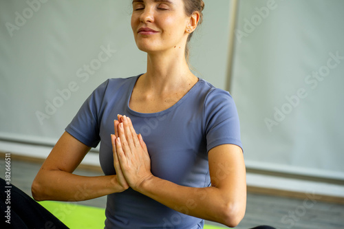 caucasian woman doing yoga exercise workout on yoga mat with instructor teaching and pose adjusting position 