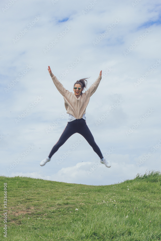 Chica feliz saltando y gritando al aire libre en tarde de invierno Chica feliz saltando y gritando al aire libre en tarde de invierno