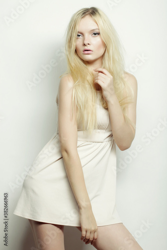 fashion blond woman in white dress posing in studio