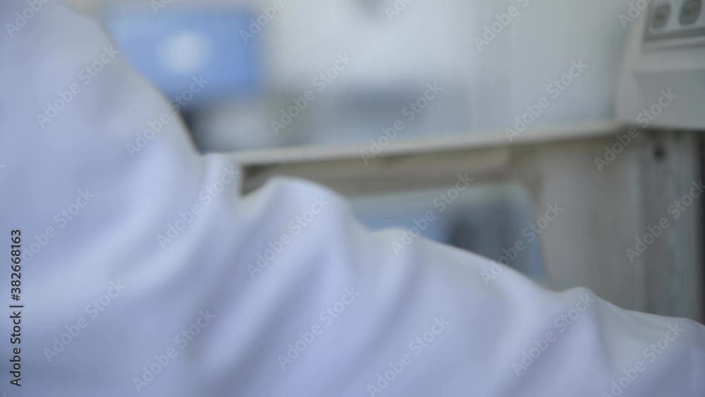 Closeup of the hand in protective glove holding test tube in the laboratory