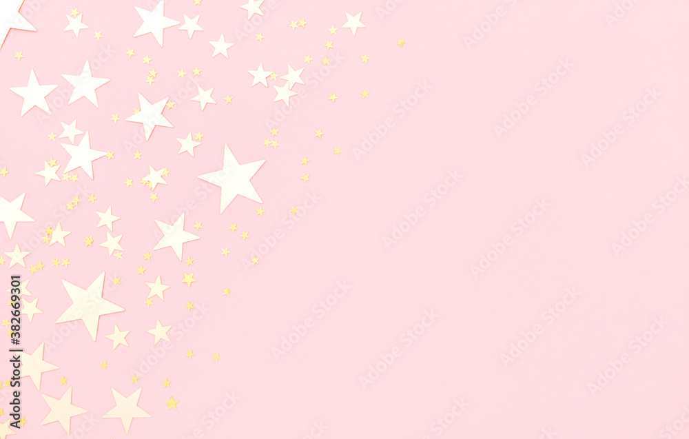 Pink pastel festive background with shining golden confetti in shape of stars.