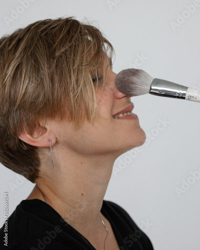 Girl with cosmetic brush on white background