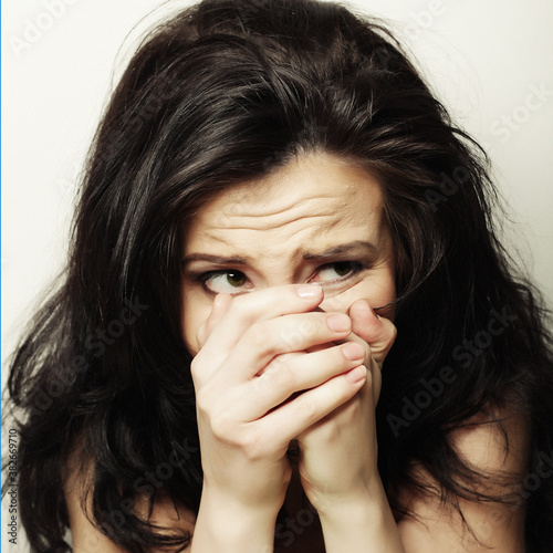 young woman covering the face with her hand