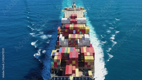 Large loaded Container Ship sailing across the ocean, Aerial view.