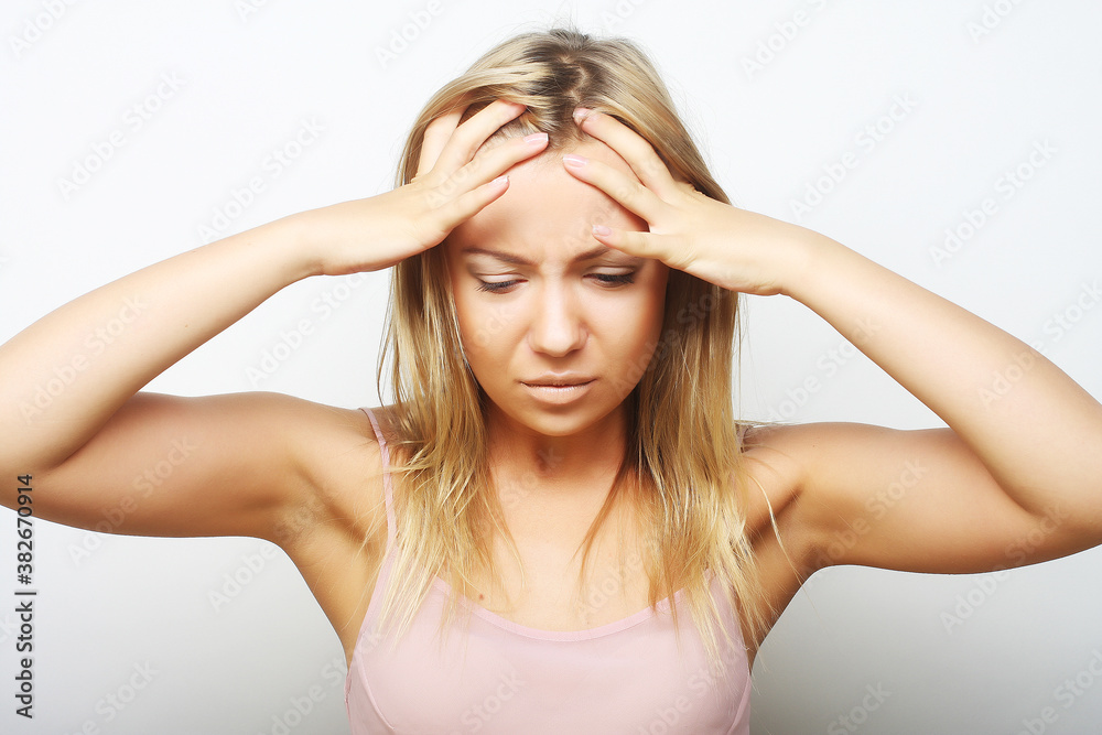 blond woman with a headache holding head