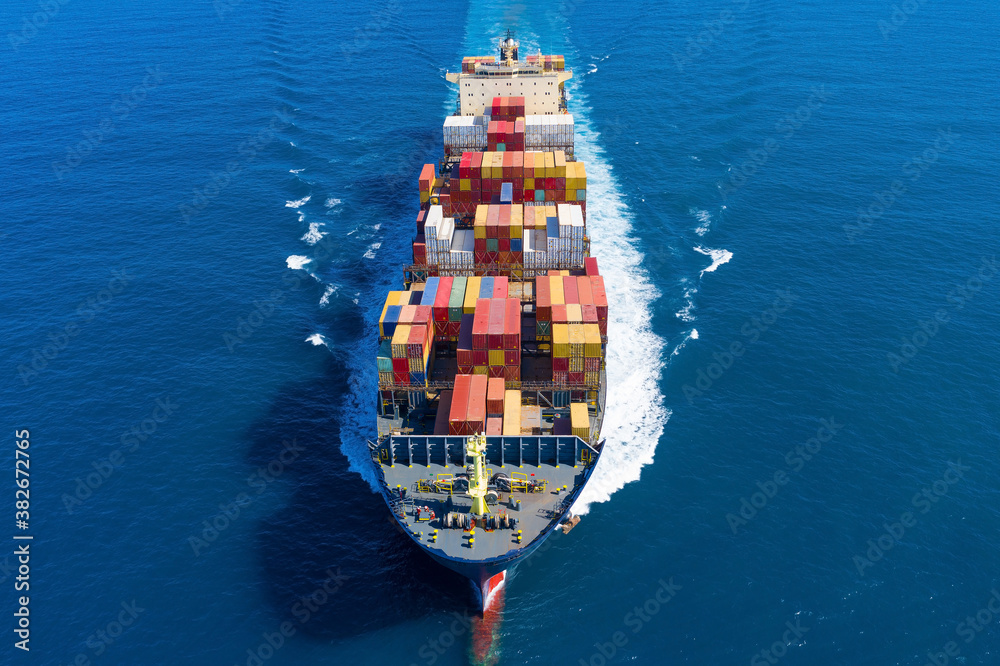 Large loaded Container Ship sailing across the ocean, Aerial view.