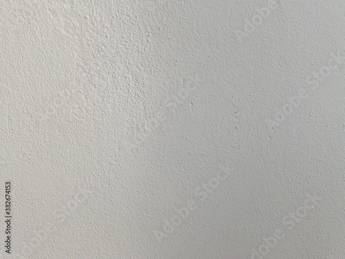 Soft smooth texture of painted wall, lit on the one side. Abstract background of white surface. Fragment