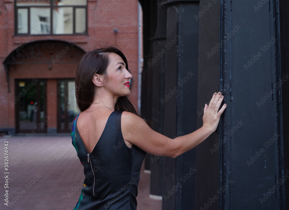 Fototapeta premium the girl stands with her back and looks out 