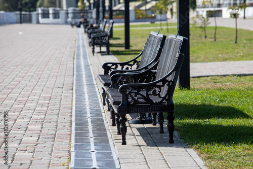 Lanterns and benches on the embankment on a clear summer day. Rest in the city on the waterfront. © Studiomiracle