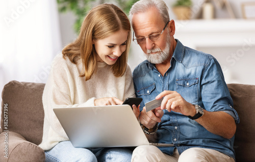 Young woman with father shopping online at home.