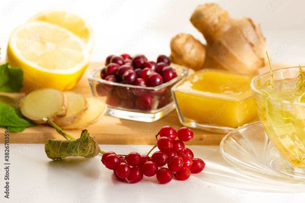 Natural products to boost immunity during a flu epidemic, coronavirus pandemic. Lemon, ginger, cranberry, viburnum, tea with lime flowers. Natural products to boost immunity during a flu epidemic, coronavirus pandemic. Lemon, ginger, cranberry, viburnum, tea with lime flowers.