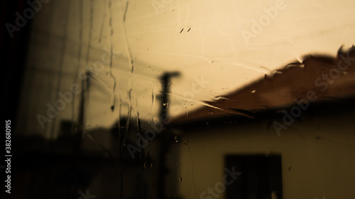 Water on the window. Rain on the window glass. Shadow on tree and nature through glass and rain. Shadow of house building photo