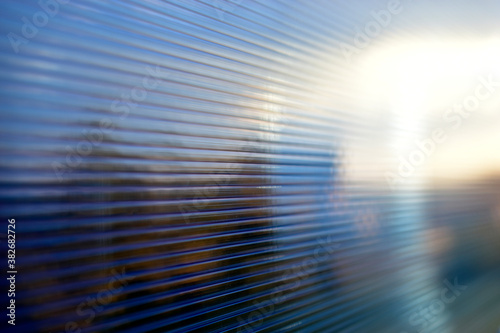 Blue surface of striped polycarbonate with a reflection of the blue distance of the city