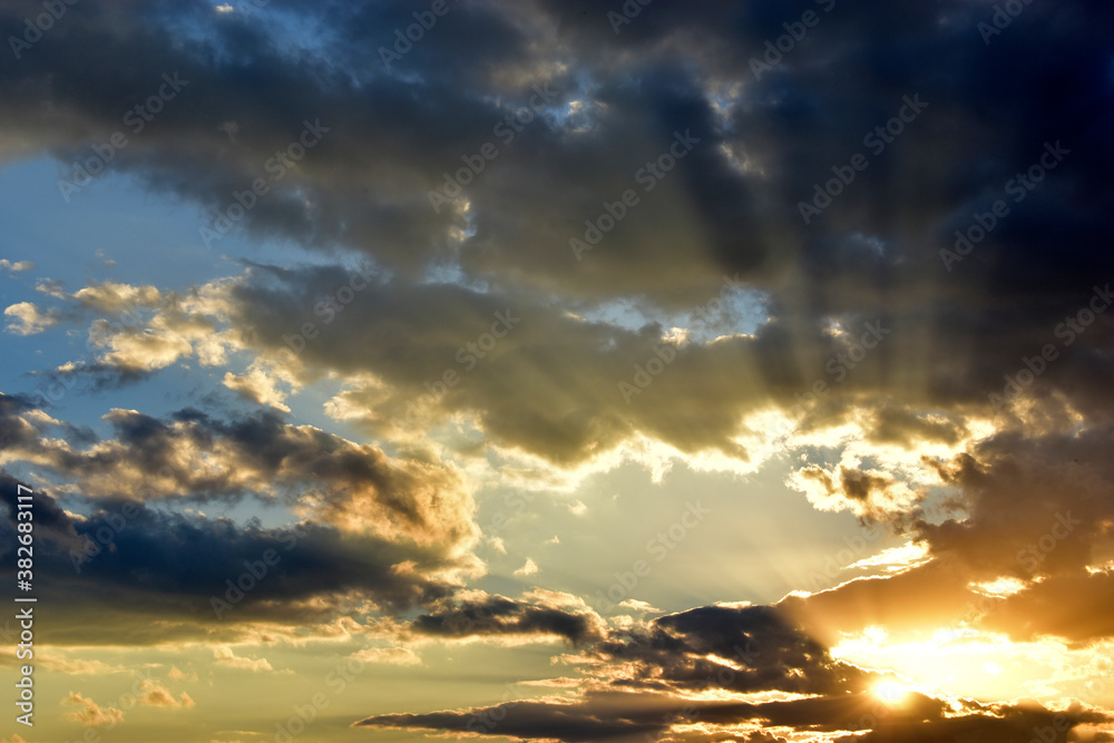 Evening sunset sky with clouds and sun rays