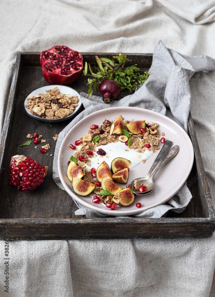 Bowl of greek yogurt with granola , fresh fig and pomegranate seeds- 