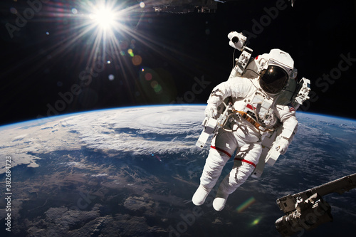 Fototapeta Naklejka Na Ścianę i Meble -  Astronaut walking in space with earth background. Elements of this image furnished by NASA