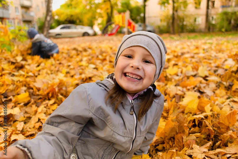 Girl plays in autumn foliage Girl plays in autumn foliage
