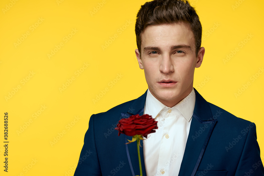 Gentlemen in classic suit on yellow background and red rose romance cropped view model portrait. Gentlemen in classic suit on yellow background and red rose romance cropped view model portrait.