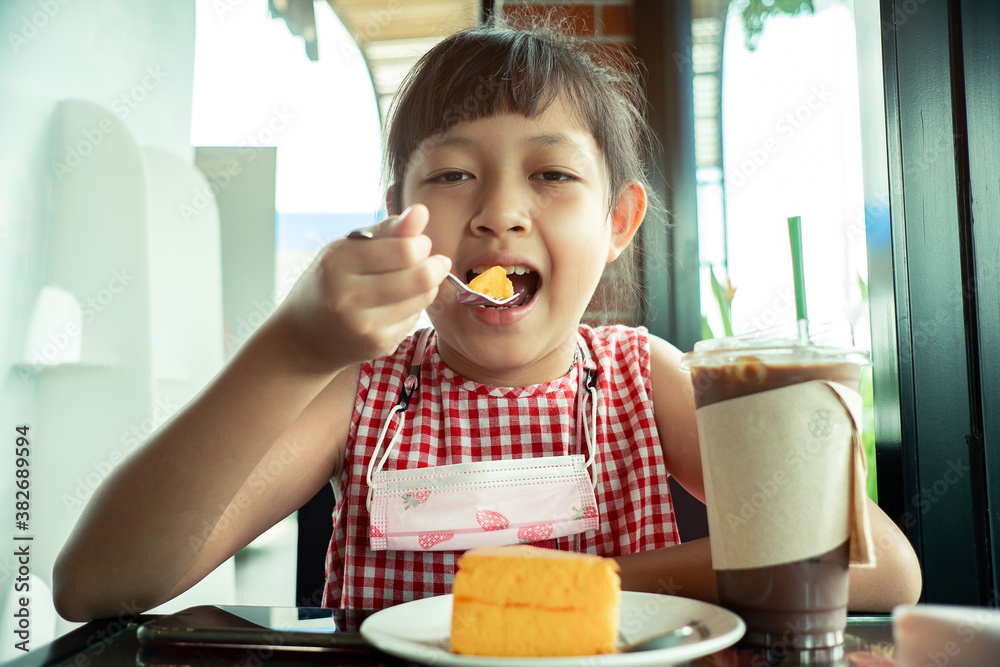 Asian little child girl eating chiffon cake Asian little child girl eating chiffon cake