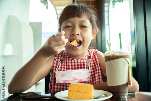 Asian little child girl eating chiffon cake