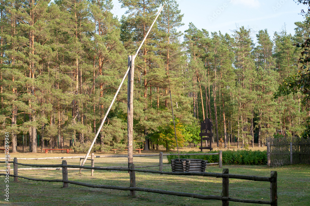 Traditional crane well of the 20th century on the background of an autumn forest Traditional crane well of the 20th century on the background of an autumn forest