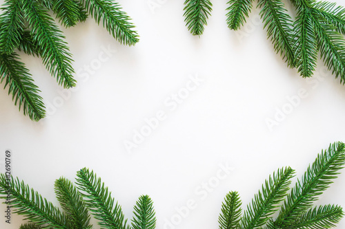 New Year background with green fir branches and pine cones/small red toys/ red snowflakes isolated on white. Winter or Christmas template for your design with copy space.