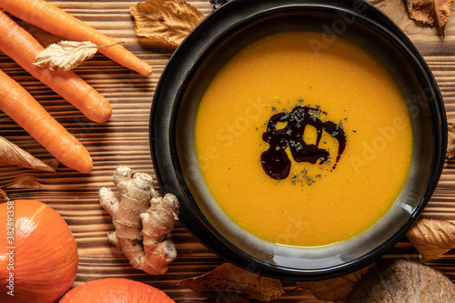 orange Suppe aus Kürbissen vom Hokkaido in einer Schale auf einem braunem Tisch aus Holz im Herbst zu Halloween photo