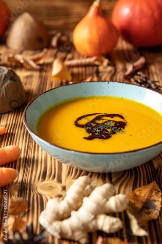 orange Suppe aus Kürbissen vom Hokkaido in einer Schale auf einem braunem Tisch aus Holz im Herbst zu Halloween photo