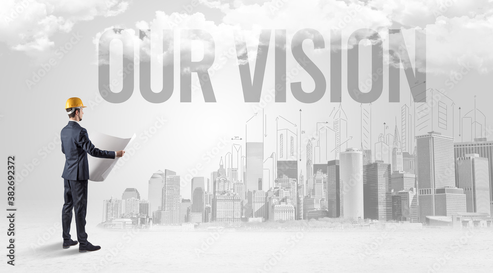 Young businessman with hard hat and OUR VISION inscription, new business opportunity concept Young businessman with hard hat and OUR VISION inscription, new business opportunity concept