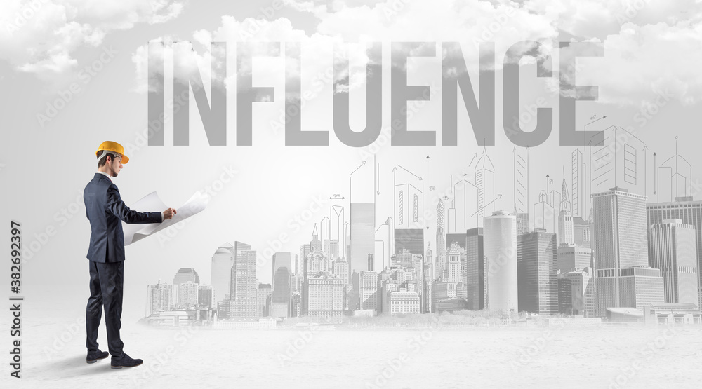 Young businessman with hard hat and INFLUENCE inscription, new business opportunity concept Young businessman with hard hat and INFLUENCE inscription, new business opportunity concept