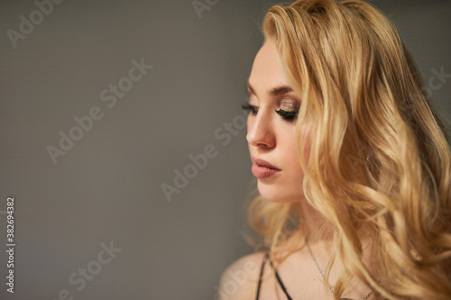 Beautiful portrait of blonde model girl with long curly hair.