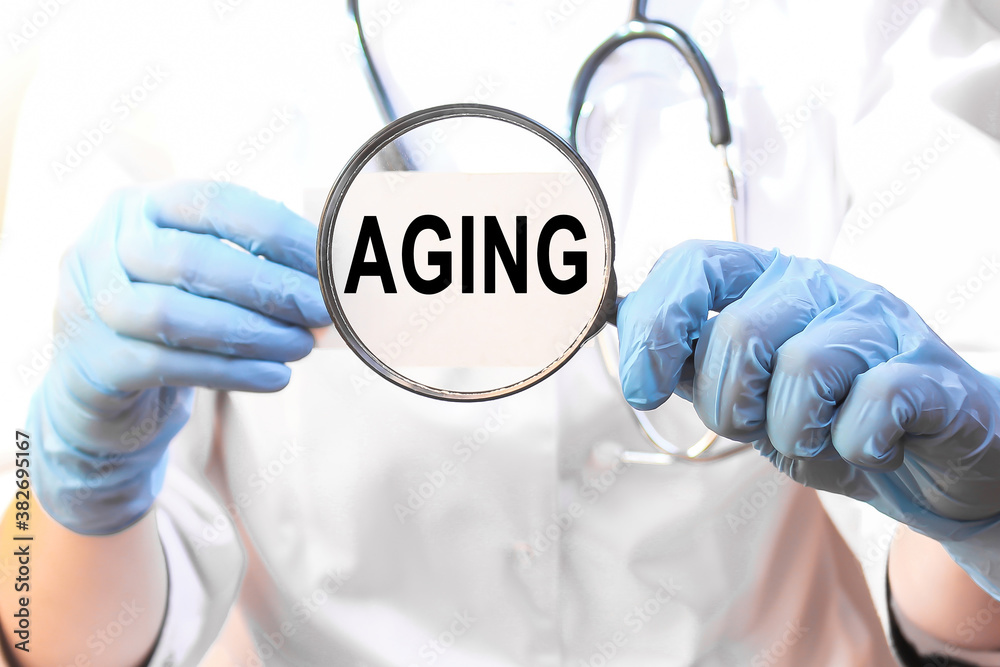 Doctor holding a card with text AGING, medical concept Doctor holding a card with text AGING, medical concept